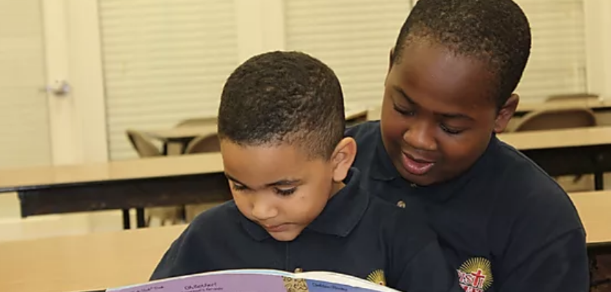 child reading to another, older child