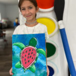 Girl holding a painting of a sea turtle